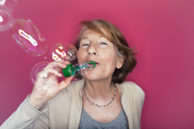 Senior woman blowing soap bubbles