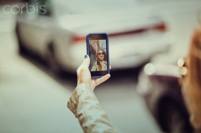 woman taking a selfie on a city sidewalk