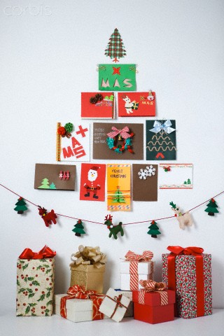 Christmas tree built with Christmas cards with gifts underneath
