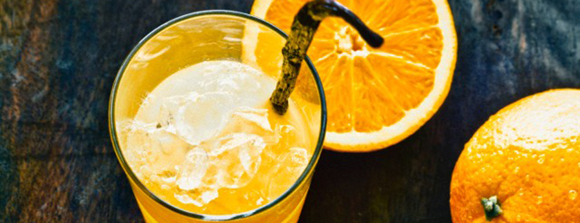 Orange juice with a vanilla pod and ice cubes